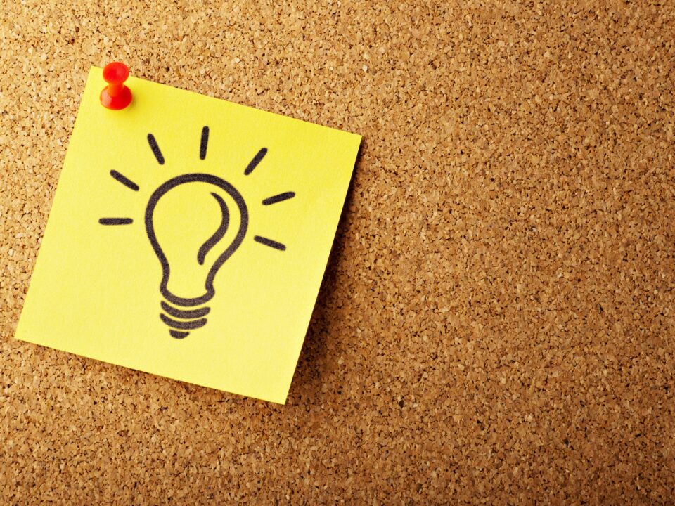 A lightbulb idea sketched on a sticky note pinned to a corkboard, representing IP protection for software companies in Kenya