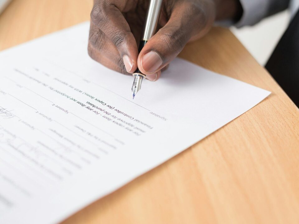 African businessman signing documents, illustrating ARIPO vs OAPI regional IP filing systems