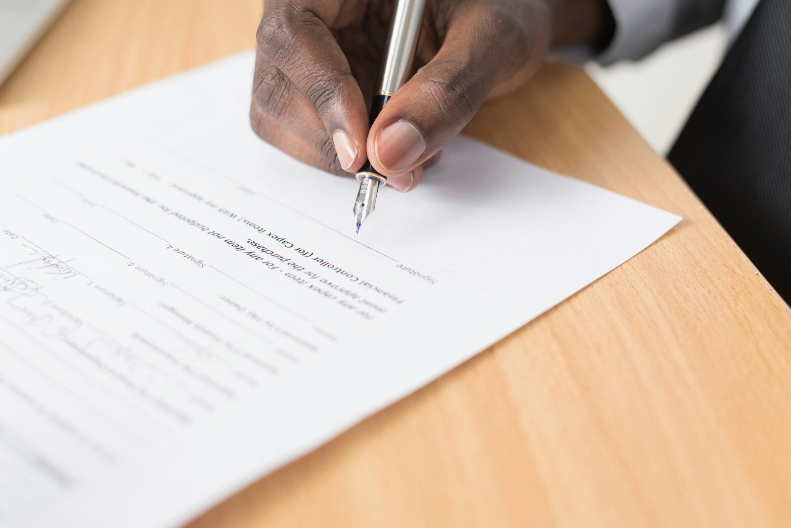 African businessman signing documents, illustrating ARIPO vs OAPI regional IP filing systems
