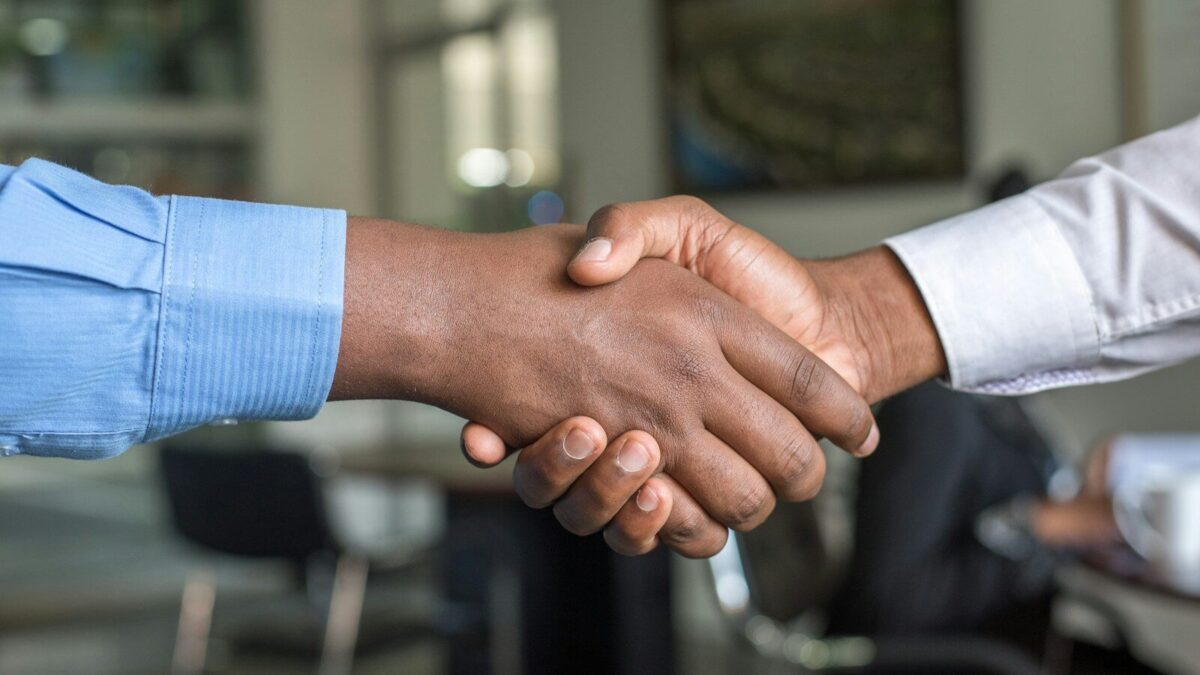 African business professionals shaking hands after a related party transaction agreement