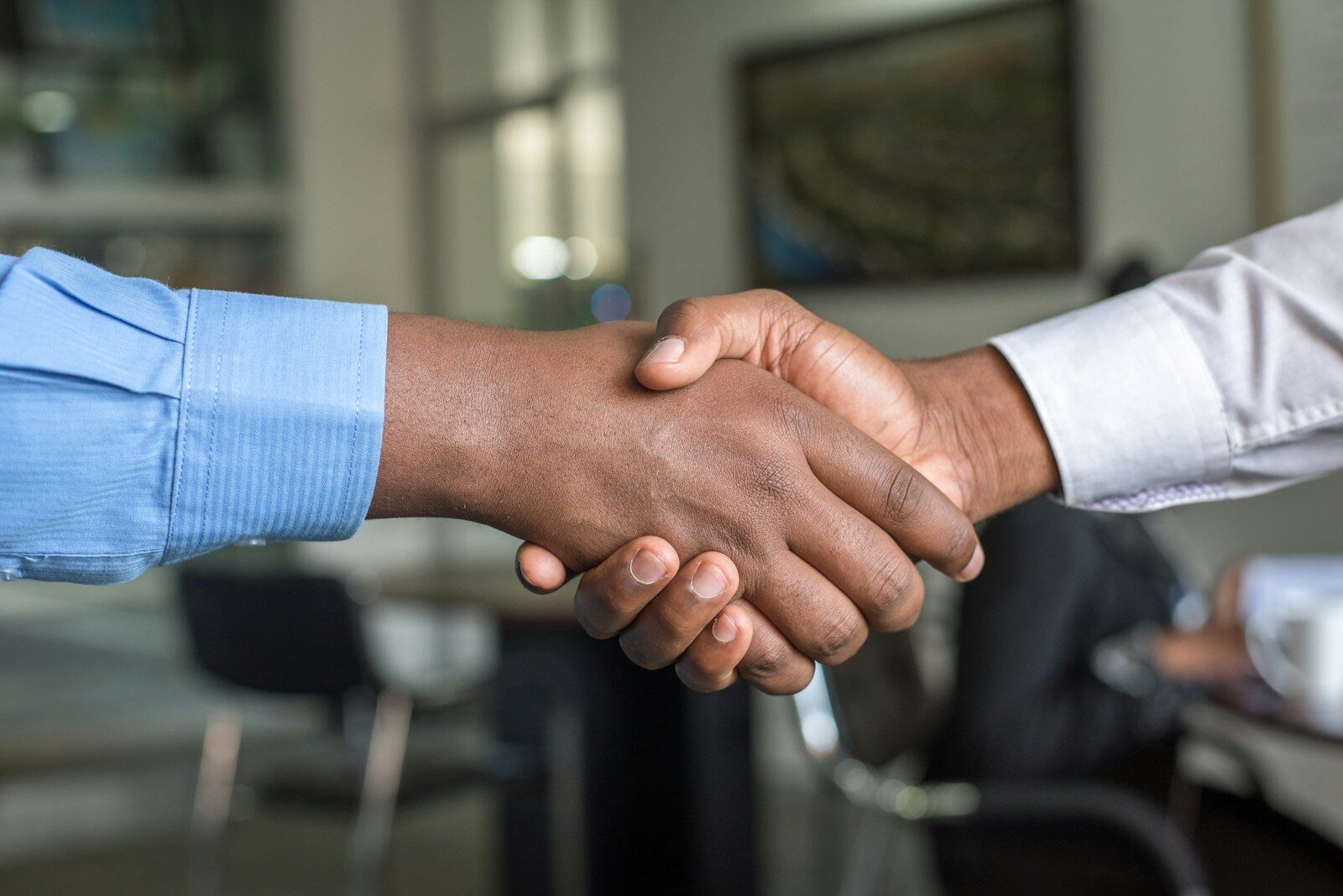 African business professionals shaking hands after a related party transaction agreement