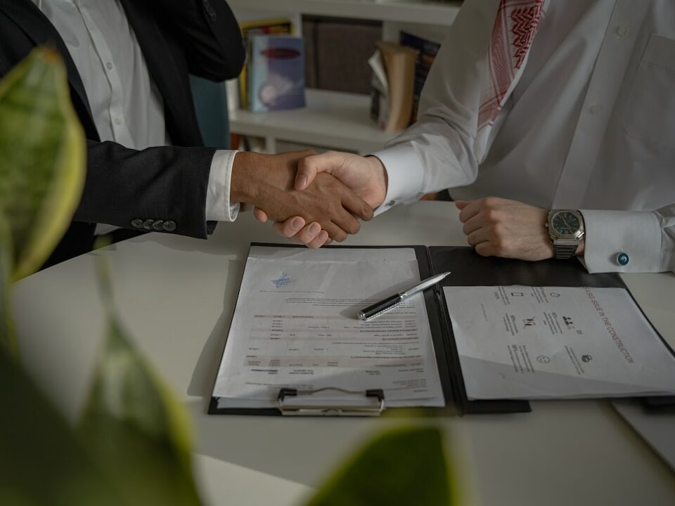 Business handshake over a signed contract representing trademark licensing and assignment in Kenya