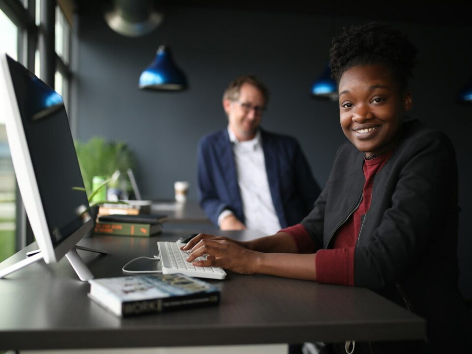 a man and a woman sitting at a desk in front of a computer