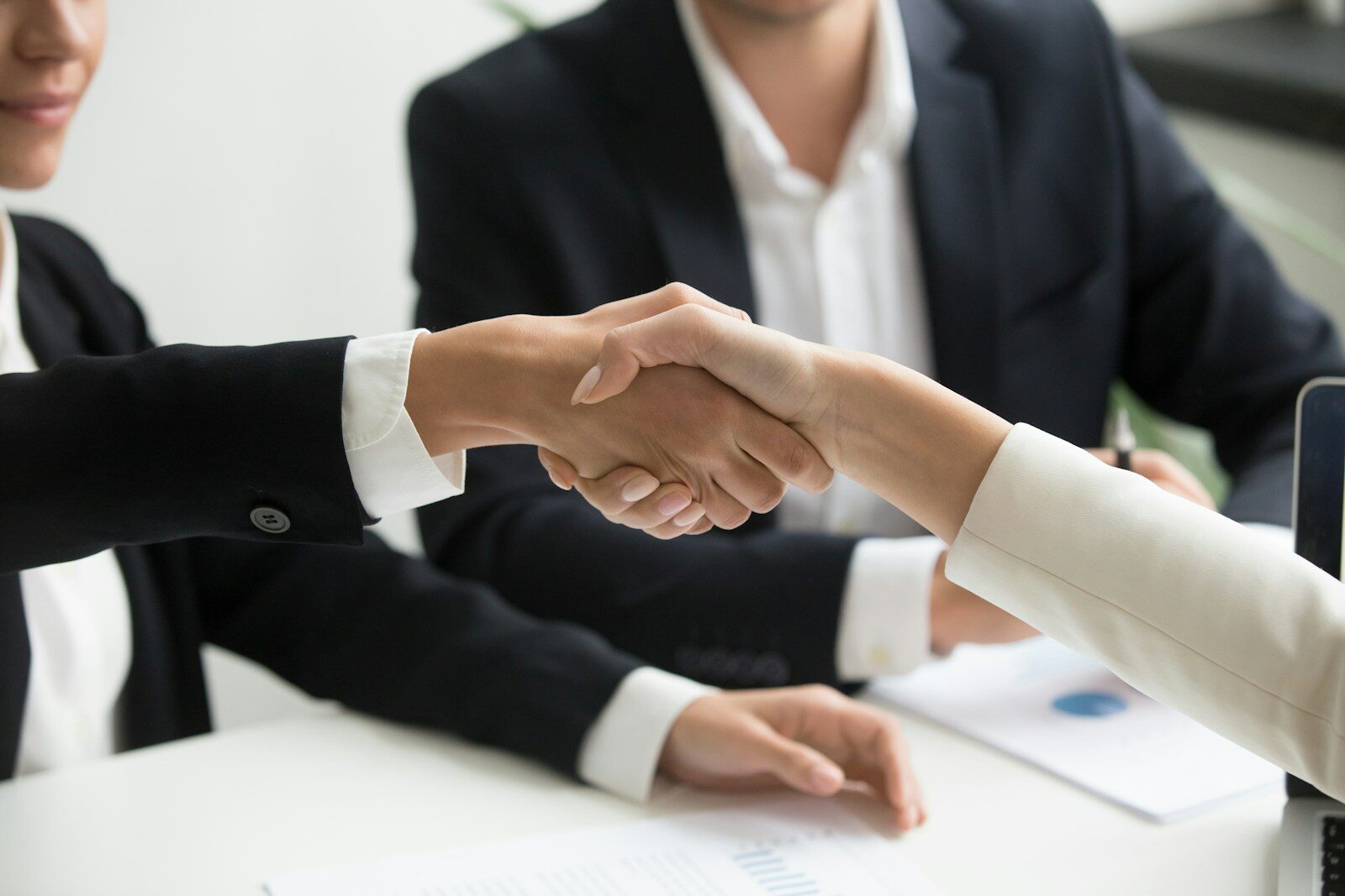 Two business people shaking hands, representing a cross-border M&A or investment transaction involving a Kenyan target’s IP portfolio