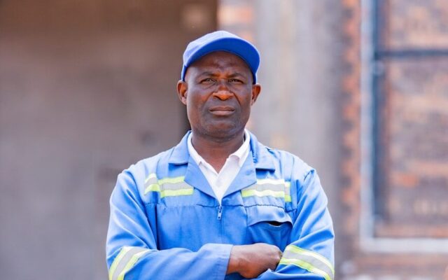 Technician in blue coveralls at a solar installation site in Kenya