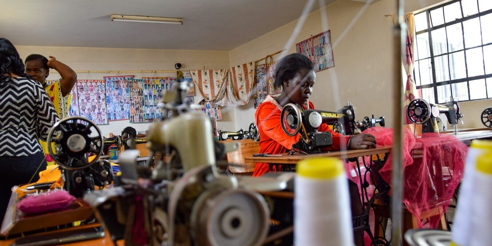Workers operating sewing machines in an African garment factory, representing process know-how and trade secrets in Kenyan manufacturing