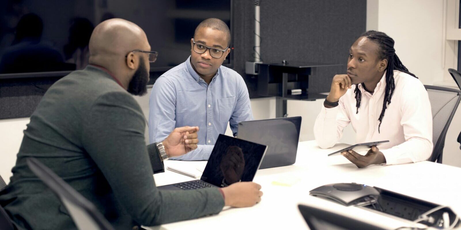 African business executives reviewing documents around a boardroom table during a due diligence discussion