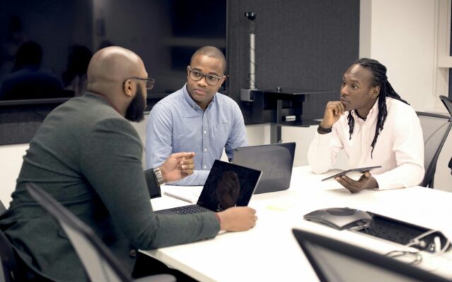 African business executives reviewing documents around a boardroom table during a due diligence discussion