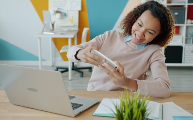A Kenyan professional using a mobile insurtech app on a smartphone in an office setting