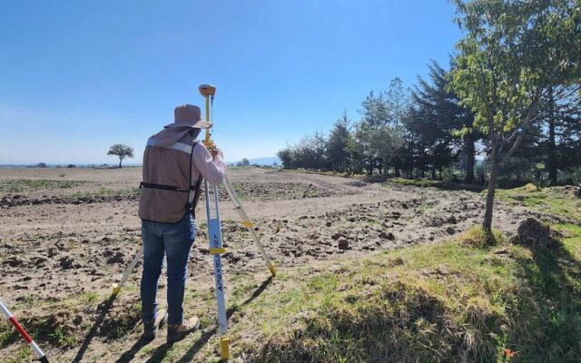 African land surveyor using a theodolite to survey rural land in Kenya
