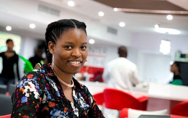 African professional working on a laptop in a modern fintech office
