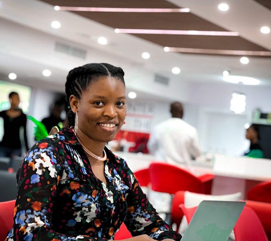 African professional working on a laptop in a modern fintech office