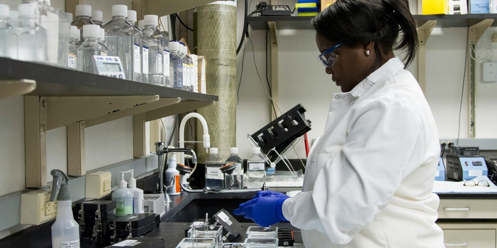 Diagnostics Laboratory Chain Kenya — African medical laboratory technician in a white coat handling samples