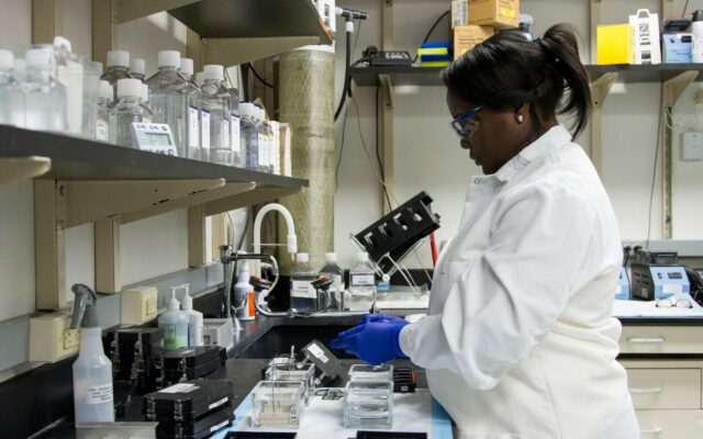 Diagnostics Laboratory Chain Kenya — African medical laboratory technician in a white coat handling samples