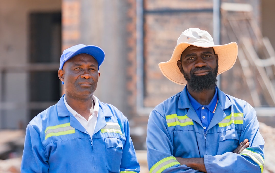 Two Kenyan manufacturing workers in blue overalls