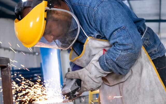 Metalworker cutting steel in a manufacturing workshop