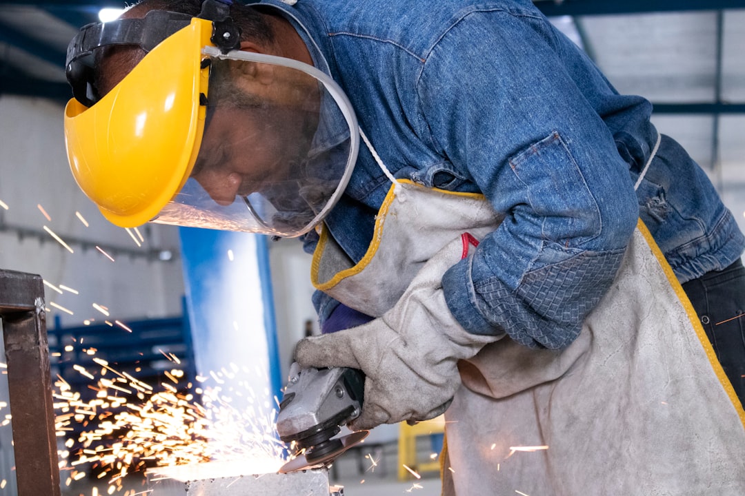 Metalworker cutting steel in a manufacturing workshop