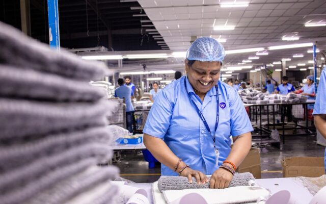 Factory worker folding finished textile products