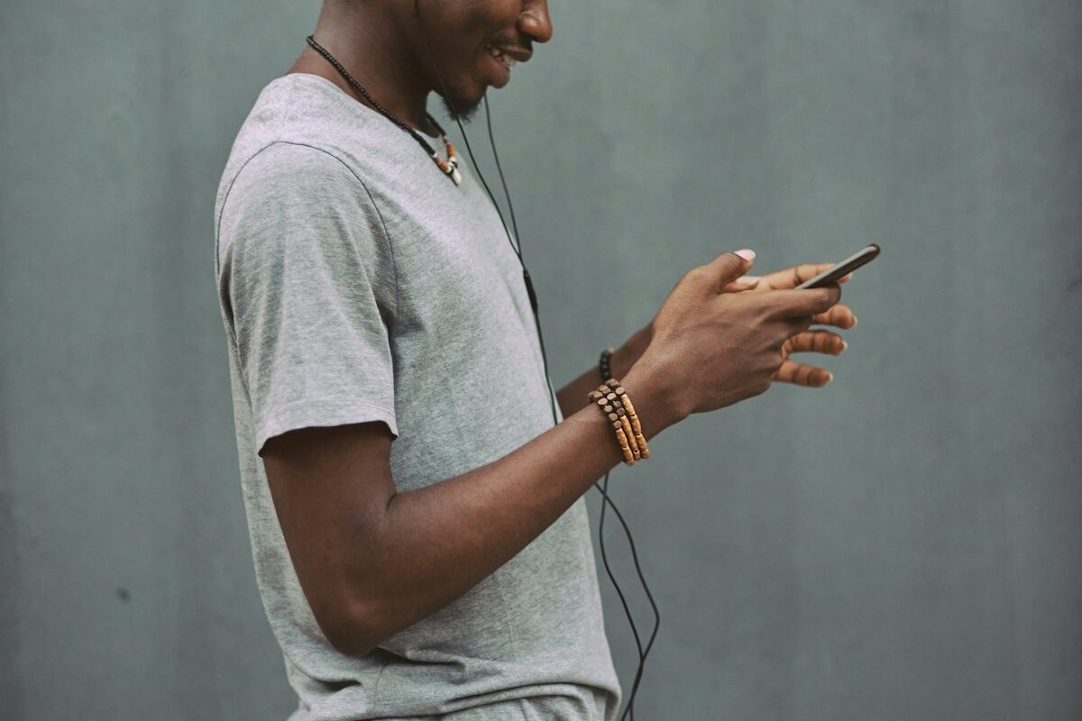 African man using a smartphone to make a mobile payment, representing payment service provider licensing in Kenya
