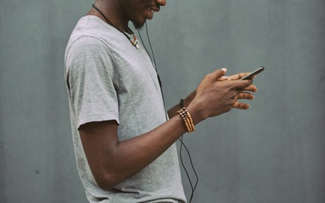 African man using a smartphone to make a mobile payment, representing payment service provider licensing in Kenya
