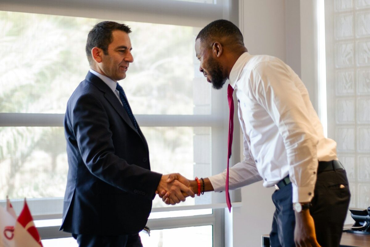 A Kenyan businessman shaking hands with a foreign investor, representing foreign ownership and market entry in Kenya financial services