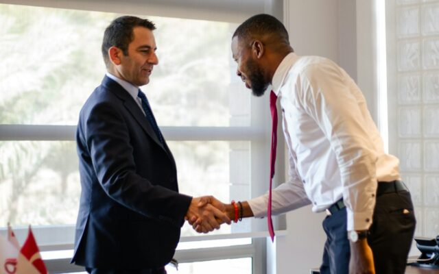 A Kenyan businessman shaking hands with a foreign investor, representing foreign ownership and market entry in Kenya financial services