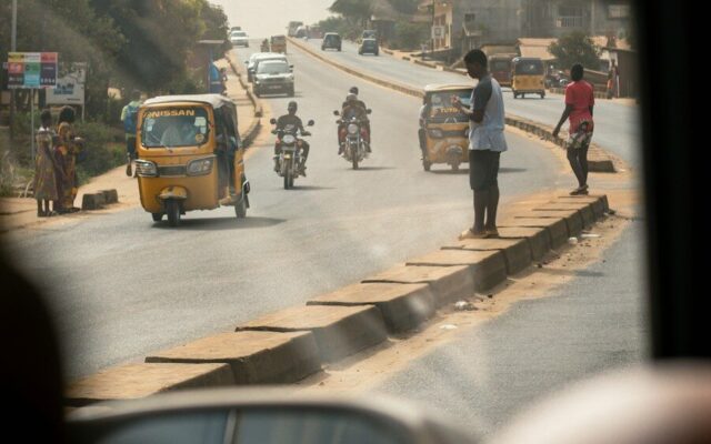 Busy African city road with tuk-tuks, motorbike taxis and pedestrians, representing the transport and ride-hailing sector affected by fare regulation in Kenya