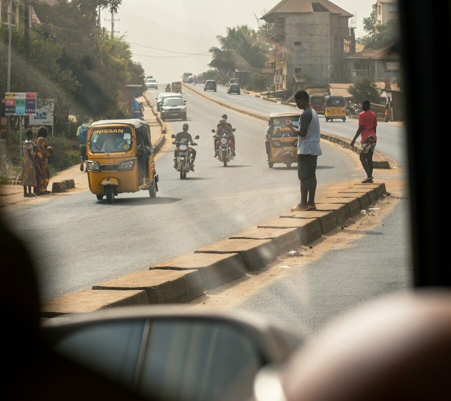 Busy African city road with tuk-tuks, motorbike taxis and pedestrians, representing the transport and ride-hailing sector affected by fare regulation in Kenya