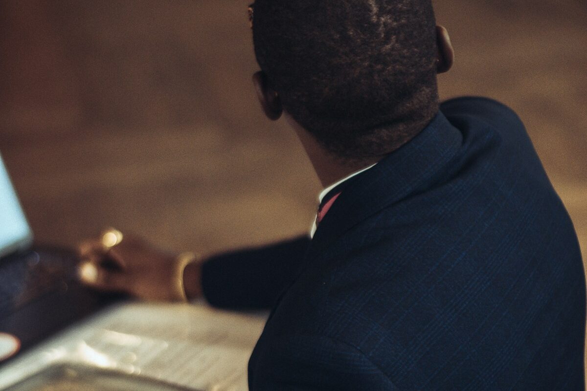 African compliance professional reviewing records on a laptop, representing AML and Travel Rule compliance for Kenya VASPs