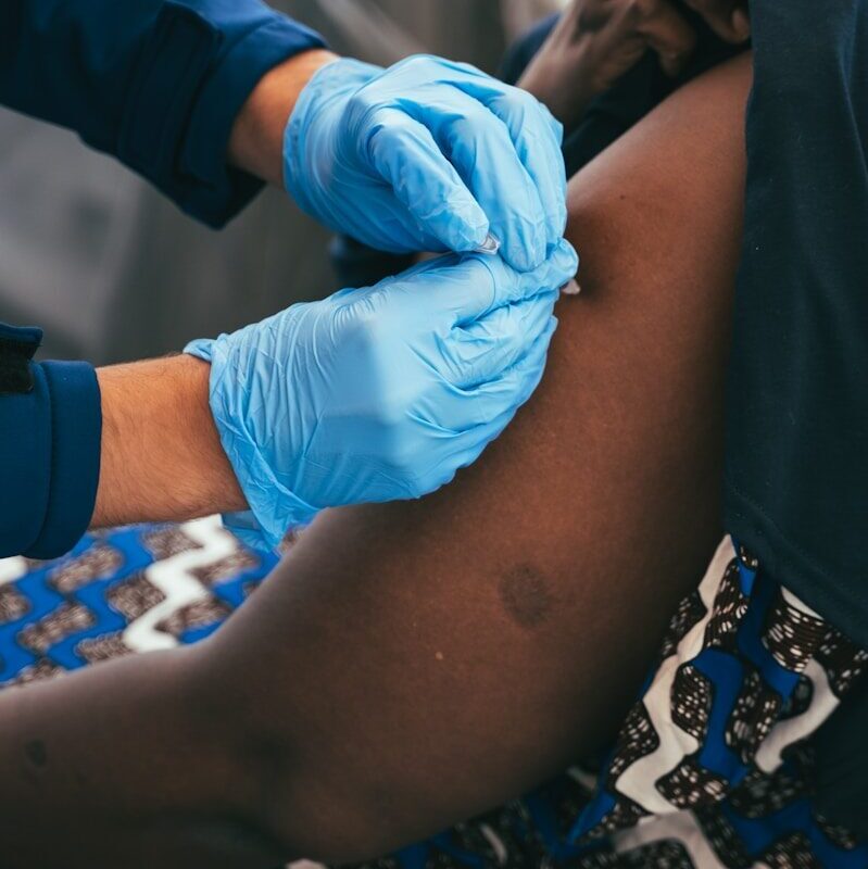 Health worker administering a vaccination to a patient in Africa, relevant to African Medicines Agency product registration