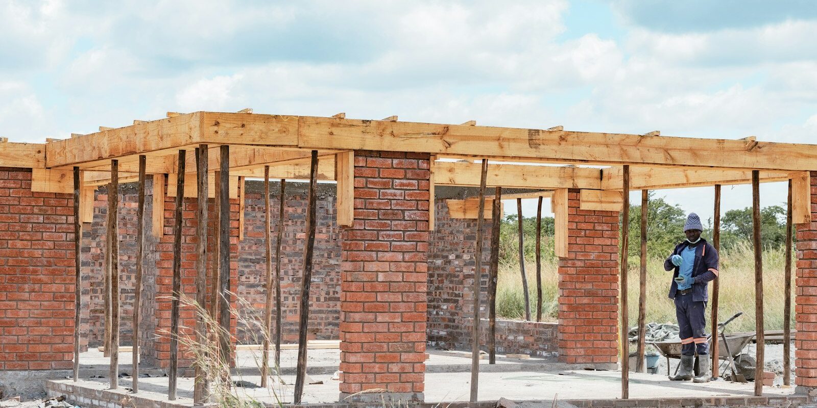 African construction worker building a brick house, representing Kenya's Affordable Housing PPP programme