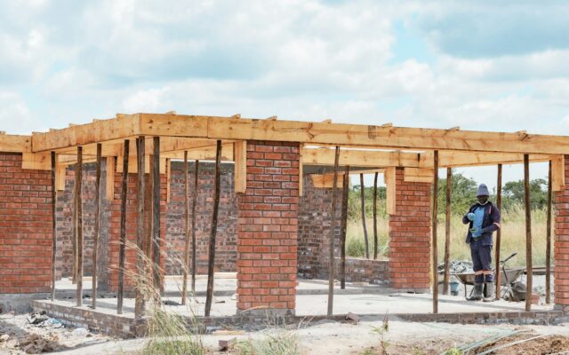 African construction worker building a brick house, representing Kenya's Affordable Housing PPP programme