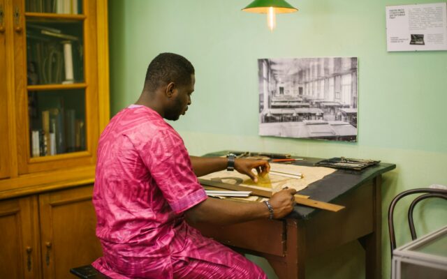 90-day regularisation: an African business owner at a desk putting permits and licences in order