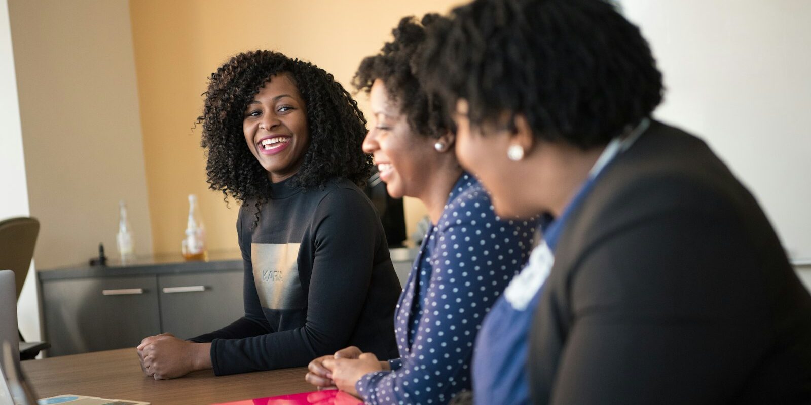VAT rule on outsourced staff: three African professional women in a team meeting at an office table
