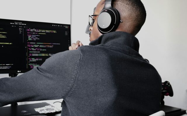 African software developer working at a dual-monitor coding setup