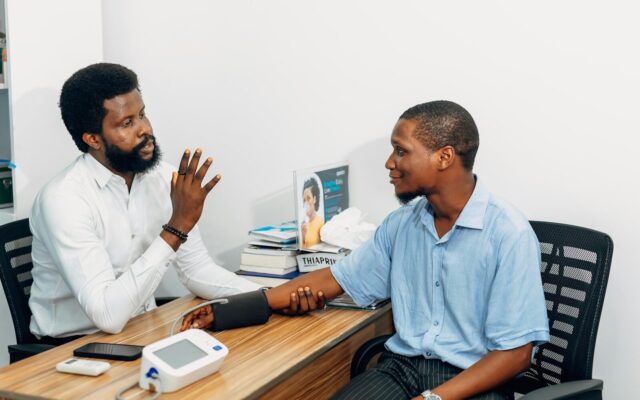 African doctor discussing medicine access and treatment options with a patient during a consultation
