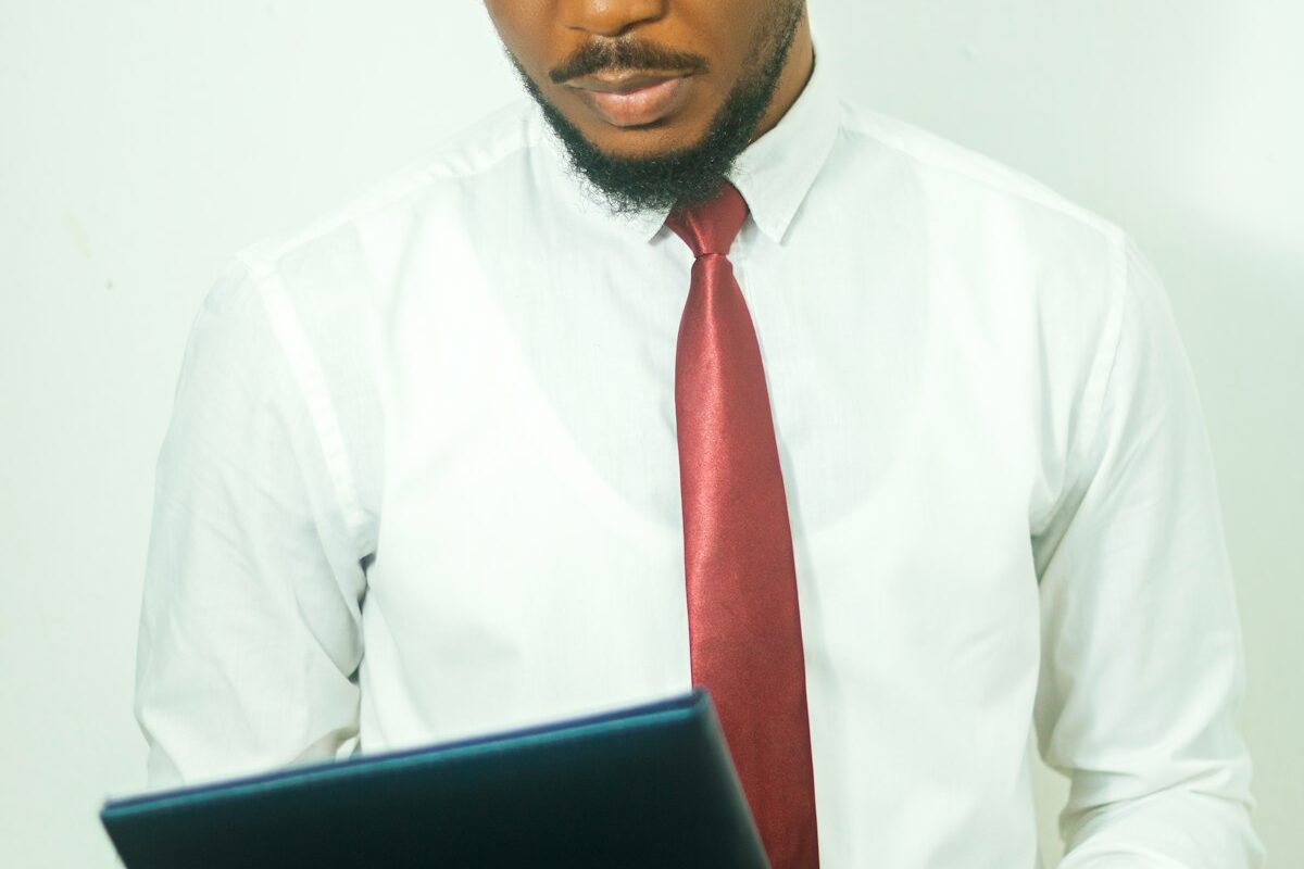 A businessman in a shirt and tie reviewing a document on a tablet