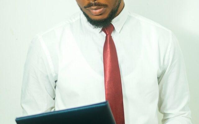 A businessman in a shirt and tie reviewing a document on a tablet