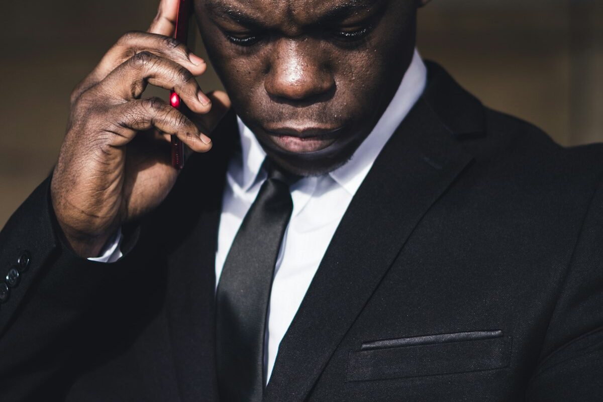 A concerned businessman on the phone checking his watch