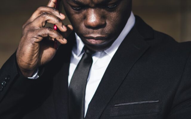 A concerned businessman on the phone checking his watch