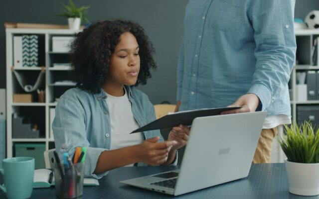 Two colleagues reviewing company documents at an office desk