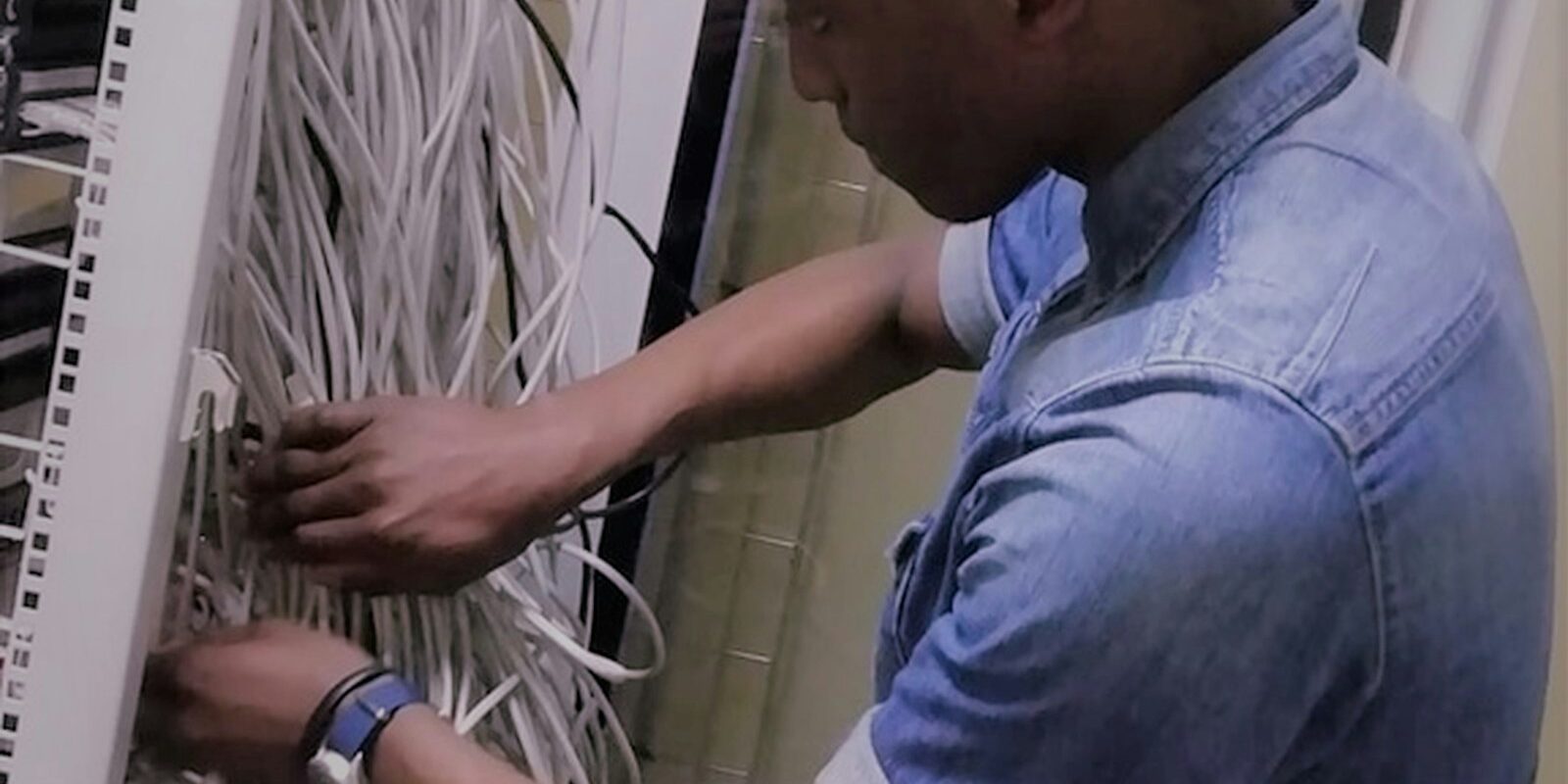 African IT technician working on a server network rack