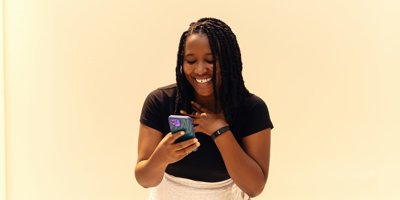 African woman smiling while using a mobile lending app on her smartphone