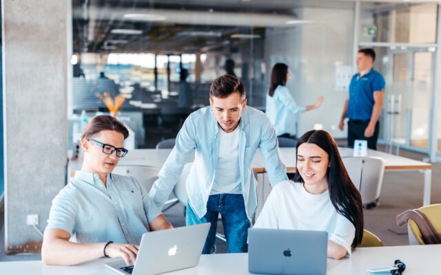 Colleagues reviewing information together on laptops in an office