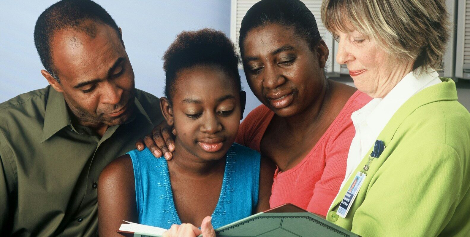 Family reviewing a care plan with an adviser, illustrating a trust set up for a disabled or vulnerable family member in Kenya