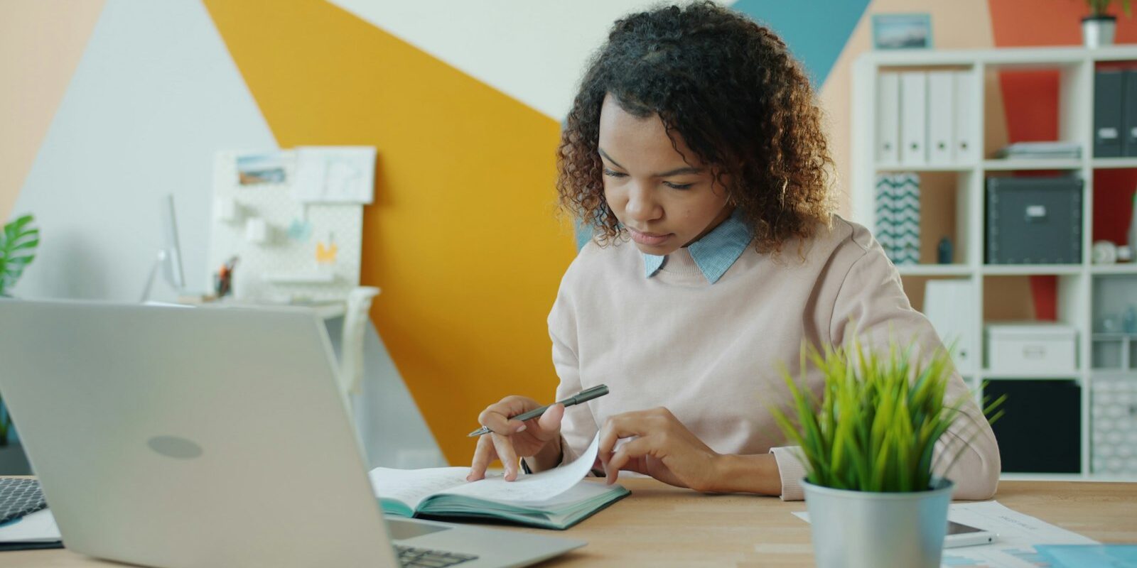 African woman employee reviewing documents at a desk during an internal workplace investigation
