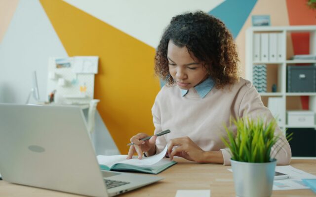 African woman employee reviewing documents at a desk during an internal workplace investigation