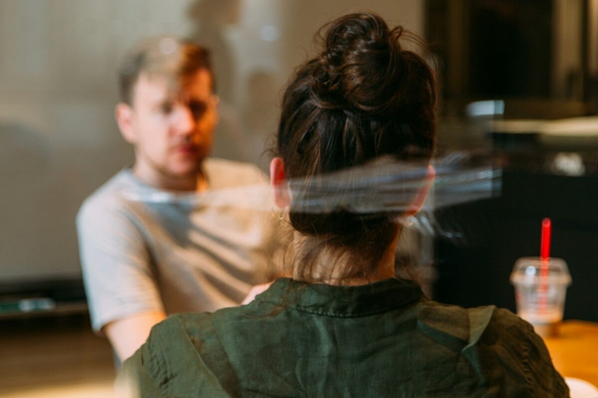 Two colleagues in a private one-on-one conversation at a table
