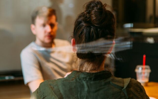 Two colleagues in a private one-on-one conversation at a table