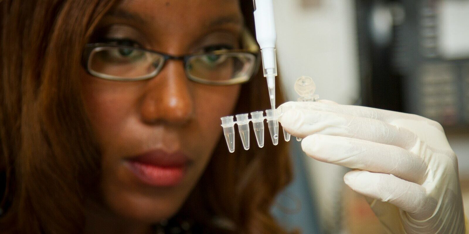 African scientist using a pipette to prepare samples during vaccine and biologics research